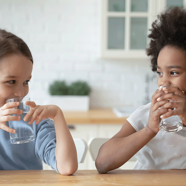 2 children drinking water together