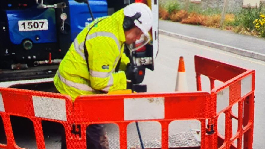 man unblocking a sewer with rods