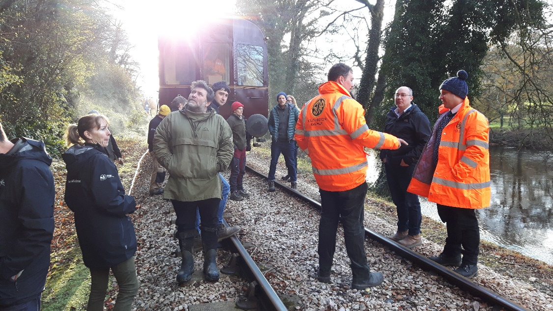 People in safety gear inspecting banks next to railway