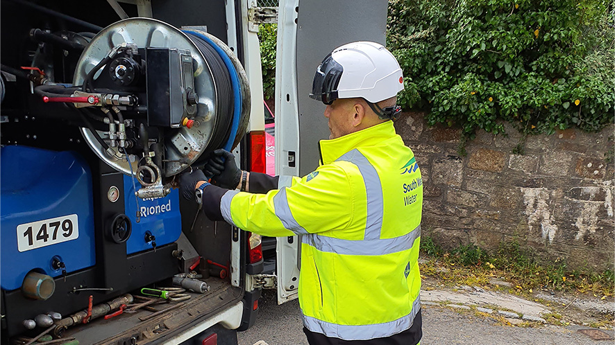 Wastewater operative pulling out jetting hose from the back of his van